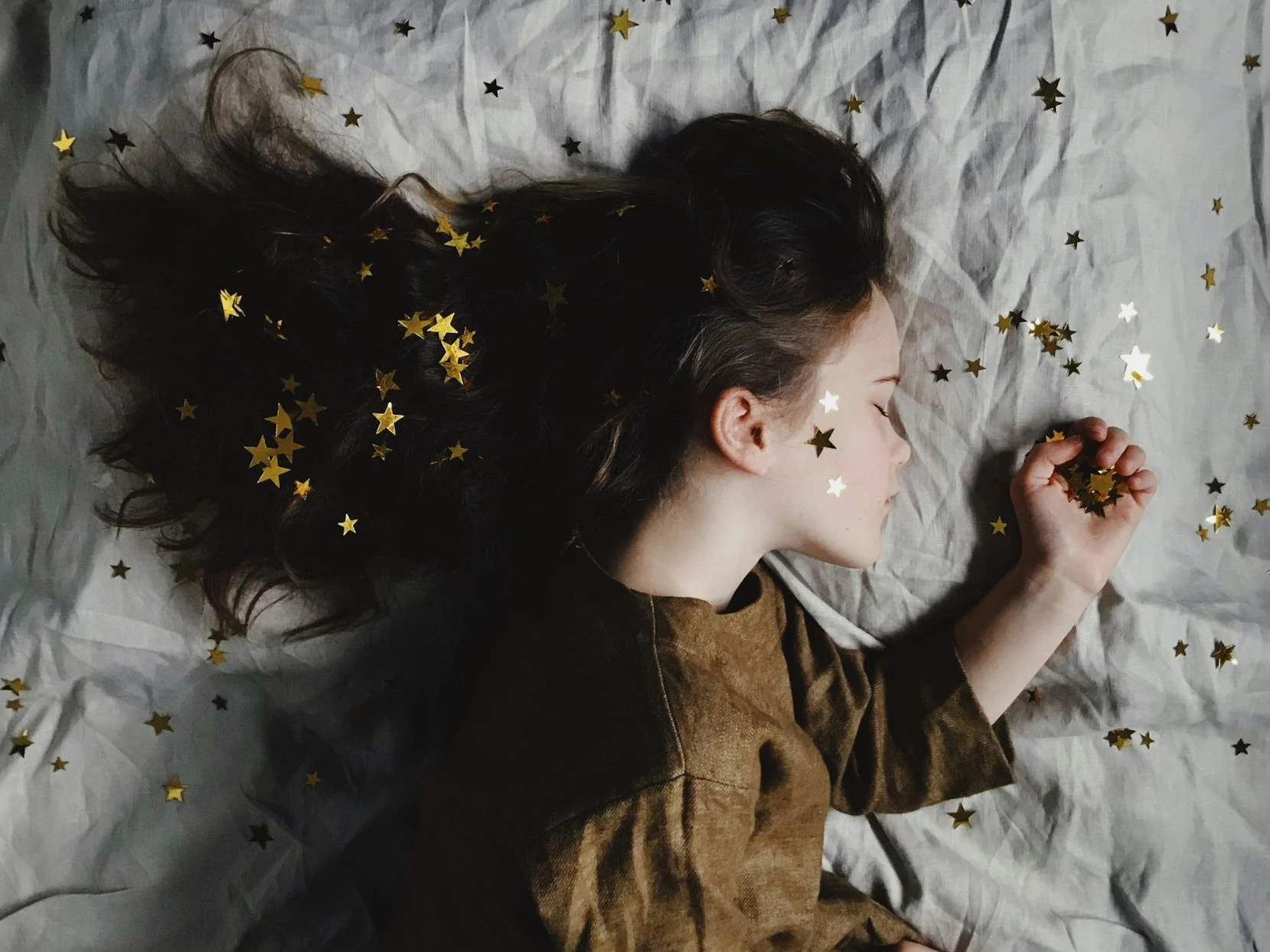 woman in brown long-sleeved top sleeping on bed